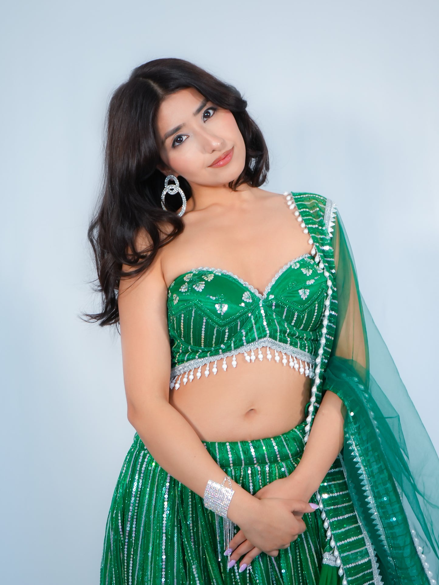 Woman wearing a green traditional outfit with a white background