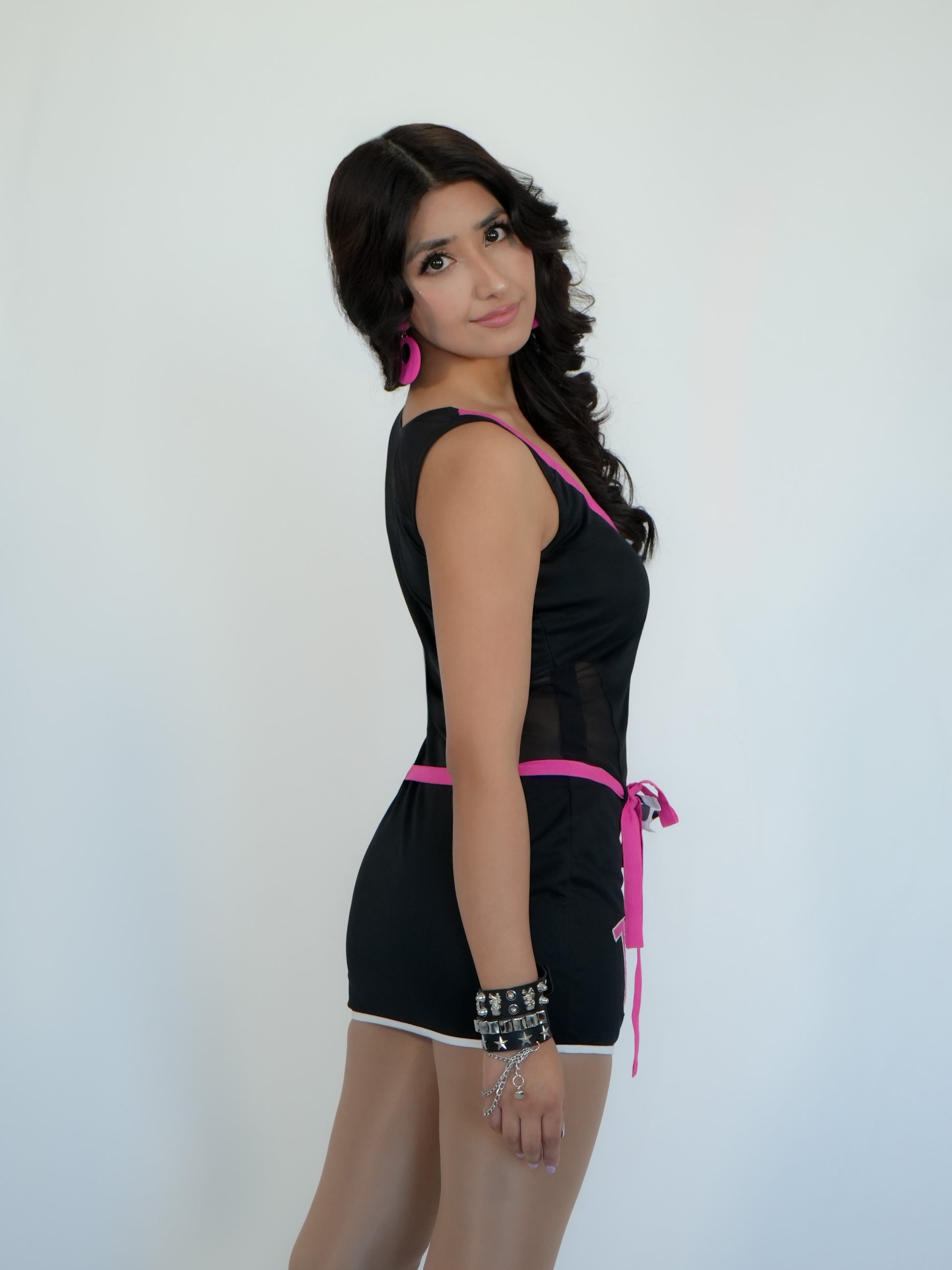 Black lycra bodycon mini dress for women featuring pink contrast detailing and sporty number print design. Made from premium stretchable lycra fabric, this dress offers a smooth, flexible fit that enhances curves while ensuring all-day comfort. The sleeveless design, mini length, and stylish waist tie add a bold and trendy touch. Perfect for club wear, parties, night outings, and fashion shoots, this outfit delivers a sporty yet glamorous vibe. Inspired by modern Bollywood style, it pairs effortlessly with 